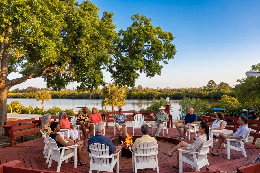 Residents gathered around a firepit at dusk, River Vista RV