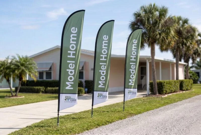 Three Model Home feather flags beside a driveway