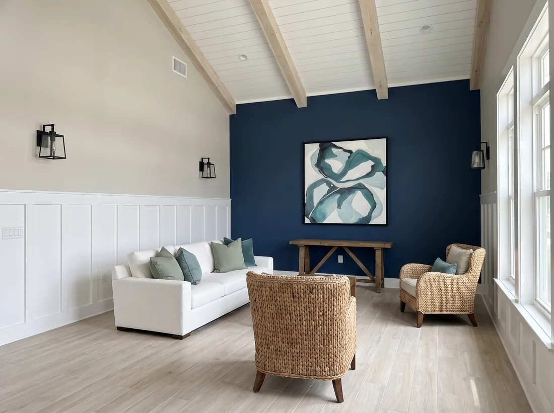 Concept rendering of a clubhouse lounge with a deep navy accent wall, a white sofa, and woven armchairs